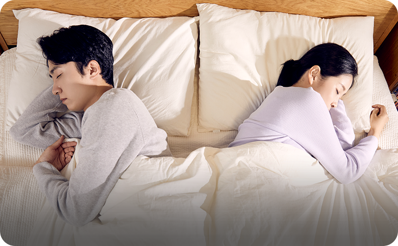부부 관계상담 안내에 사용된, 침대에서 서로 등을 돌리고 누운 부부 사진