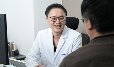 진료실에서 마주 앉은 사람과 대화하는 잠실 산비오의원 비뇨기과 전문의 정지윤