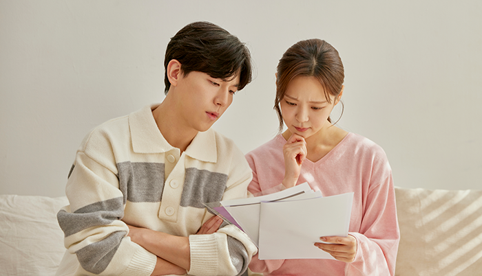 나란히 앉아 서류를 함께 읽는 남녀