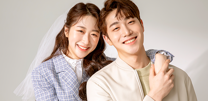 여성이 남성의 어깨를 감싸 안고 함께 미소 짓는 모습