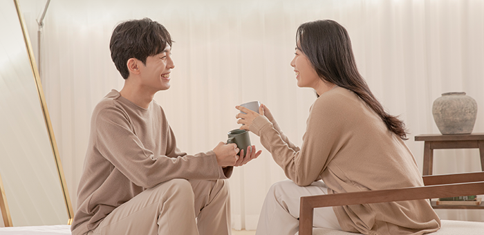 찻잔을 들고 서로 바라보며 대화하는 남녀