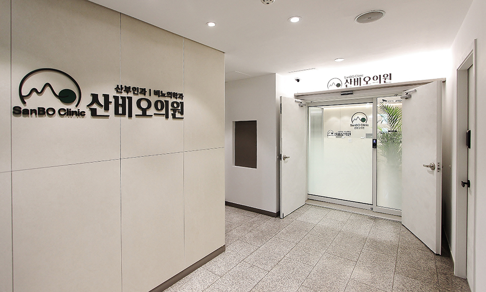 잠실 산비오의원 로고가 있는 벽과 유리 출입문