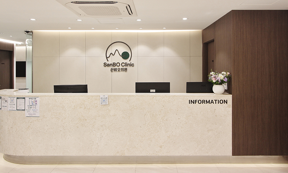 송파구 산비오의원의 로고와 INFORMATION 표기가 있는 밝은색 접수 데스크