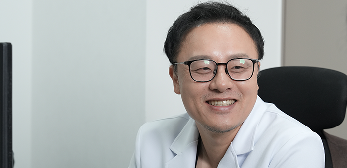 진료실에서 흰 가운과 안경을 착용하고 미소 짓는 의사