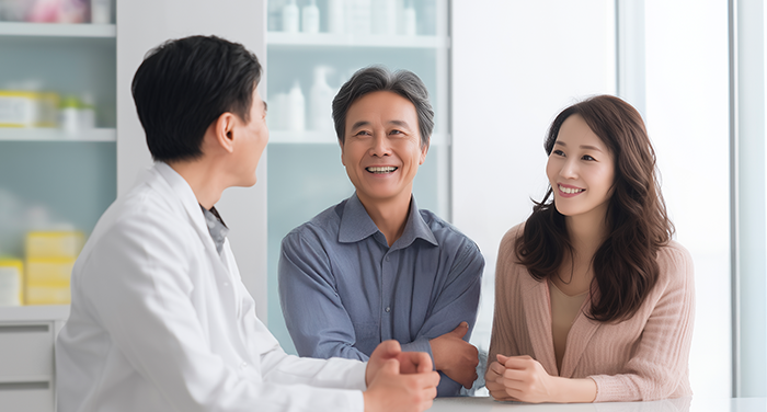 의료인과 마주 앉아 대화하는 중년 남성과 여성