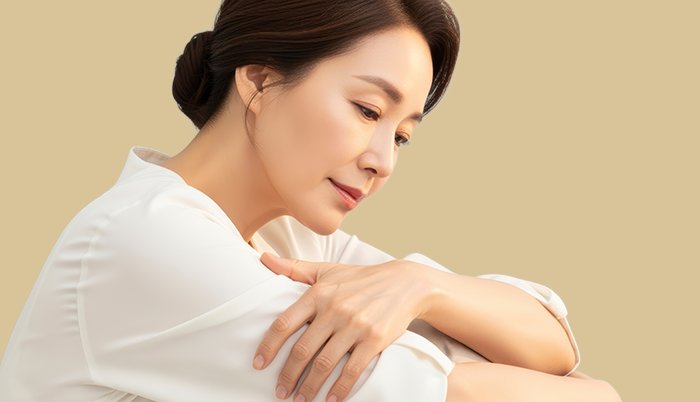 여성 자신감 변화 안내에 사용된, 팔 위에 손을 얹고 아래를 보는 여성 사진