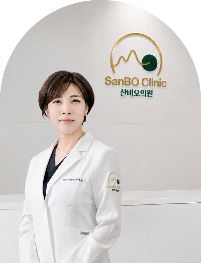 산비오 로고 앞에서 흰 가운을 입고 선 잠실 산비오의원 산부인과 전문의 허경은 대표원장