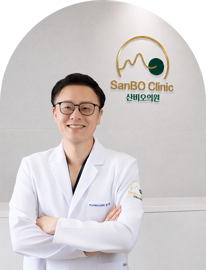 산비오 로고 앞에서 흰 가운을 입고 팔짱을 낀 잠실 산비오의원 비뇨기과 전문의 정지윤 대표원장