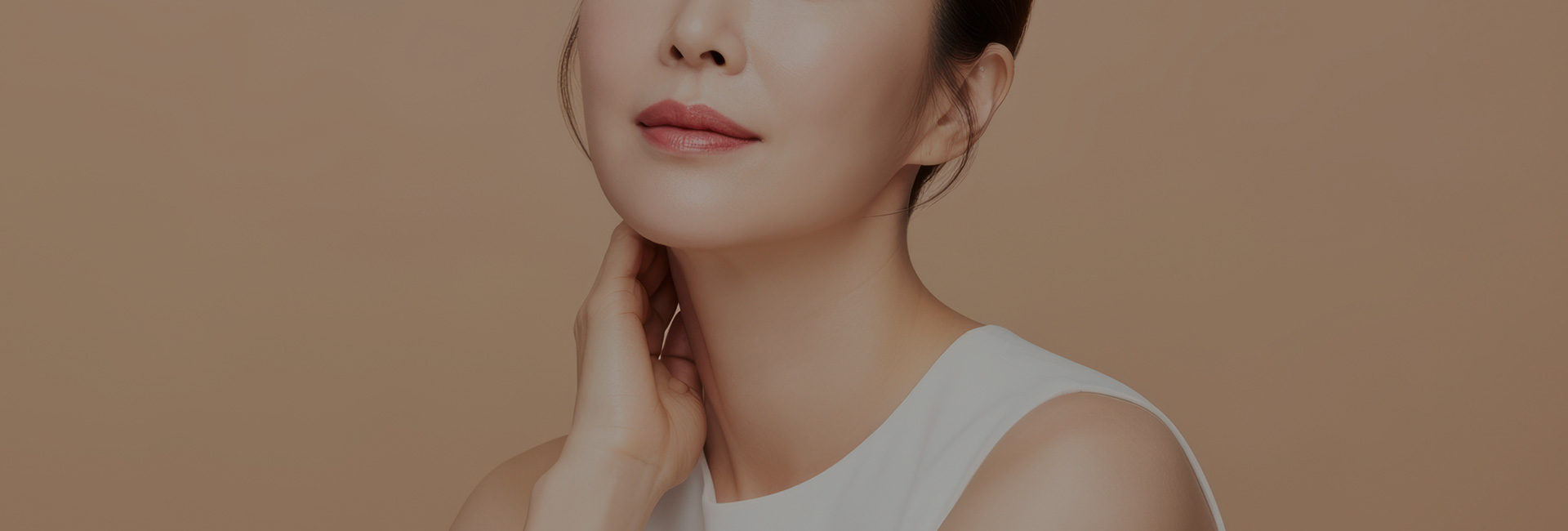 목에 손을 대고 옆을 향한 여성의 얼굴과 어깨