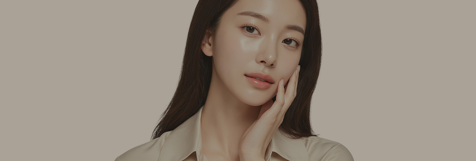 한 손을 뺨에 대고 정면을 바라보는 긴 머리의 여성